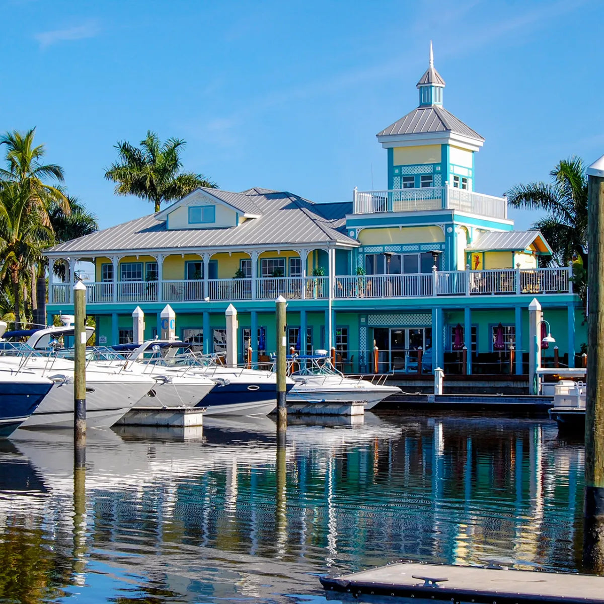 Boats docked in front of a waterfront marina building in Fort Myers